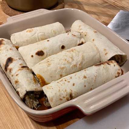 Spread 1/4 cup of sauce at the bottom of your baking dish. This will help prevent sticking and coat the enchiladas. Put as much filling as you can fit in a tortilla and roll up to form the enchiladas. Place each one in the baking dish. Pour on enchilada sauce (you don't have to use all of the sauce, we want them to be coated but not soggy) and top with cheese.